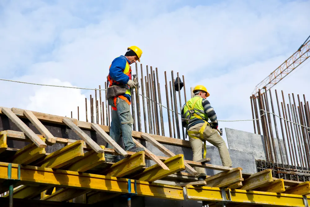 Obra civil industrial con trabajadores en casco y chaleco de seguridad